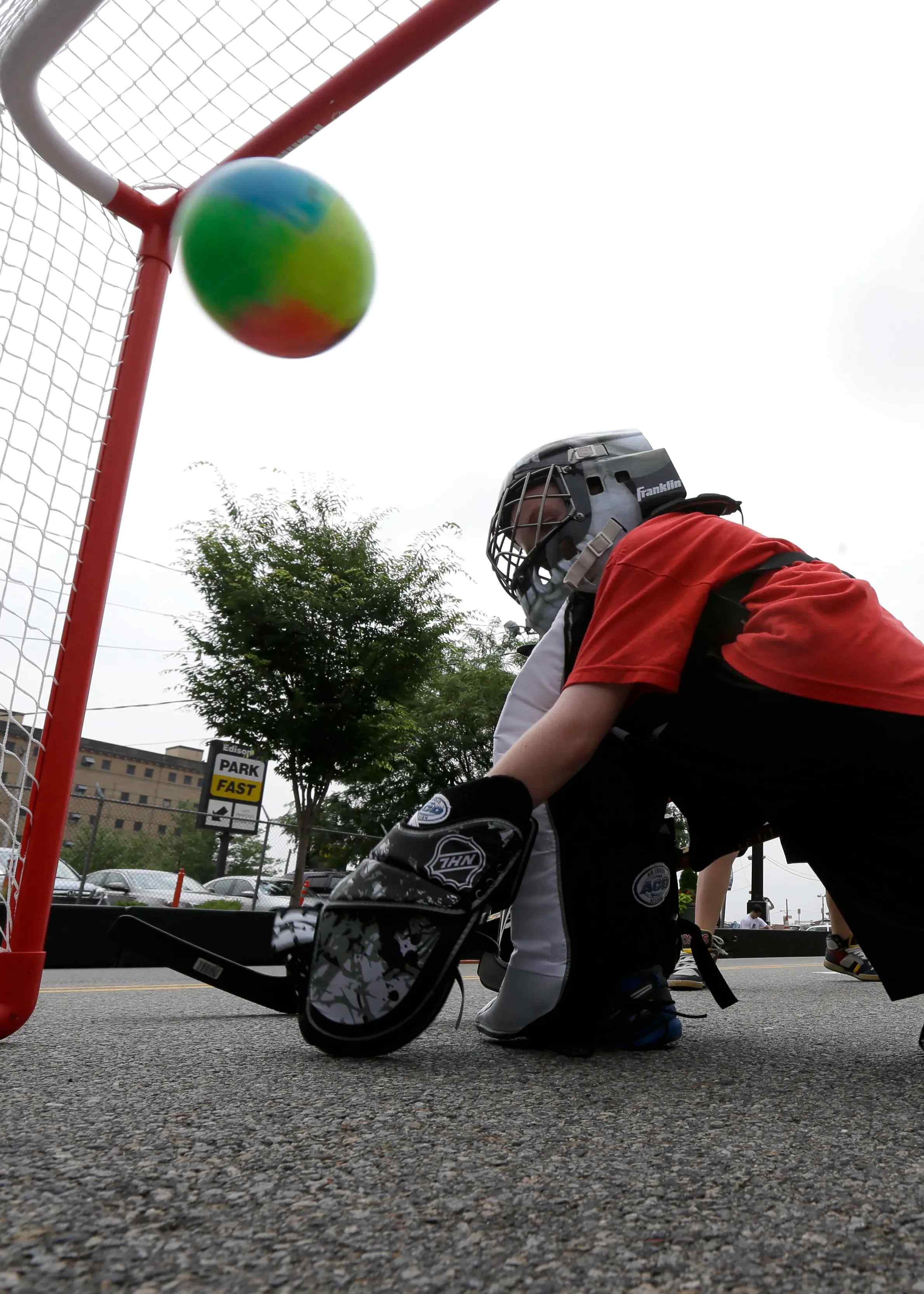 A young goalkeeper playing street hockey